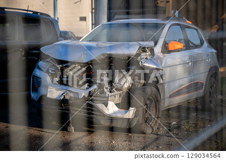 Wrecked and burned cars in scrapyard after crashes, showing severe damage and destruction 129034564