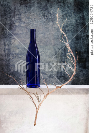 Still life with a blue bottle and a dry branch 129034723