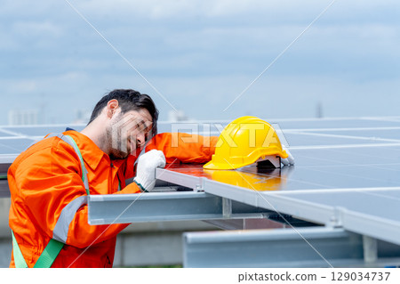 Close up professional technician worker or engineer stand near solarcell panel and relax with action of sleep or lie on area of factory or rooftop building. Close up professional technician worker or engineer stand near solarcell panel and relax with action of sleep or lie on area of factory or rooftop building. 129034737