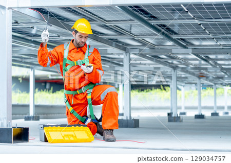 Professional technician worker or engineer look at tools for maintenance or check system under solar cell panel. 129034757
