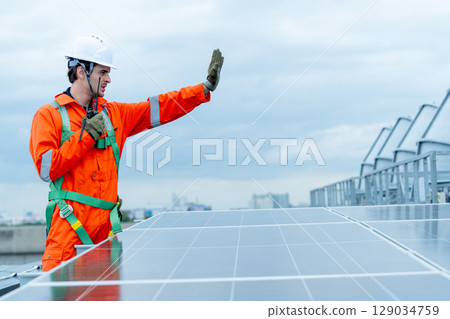 Professional technician worker or engineer stand near solar cell panel during check or maintenance in area of factory or rooftop building and show hand sign of prohibit to do somethings. Professional technician worker or engineer stand near solar cell panel during check or maintenance in area of factory or rooftop building and show hand sign of prohibit to do somethings. 129034759