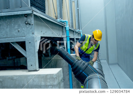 Engineer or technician worker check pipe system of factory building. Engineer or technician worker check pipe system of factory building. 129034784