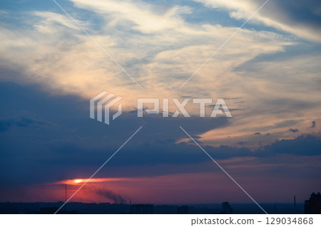 Dramatic blue sky with illuminated clouds at sunset. 129034868