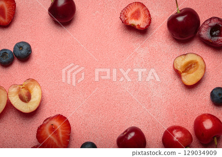Fresh fruit and berries on pink background top view with space for text Fresh fruit and berries on pink background top view with space for text 129034909