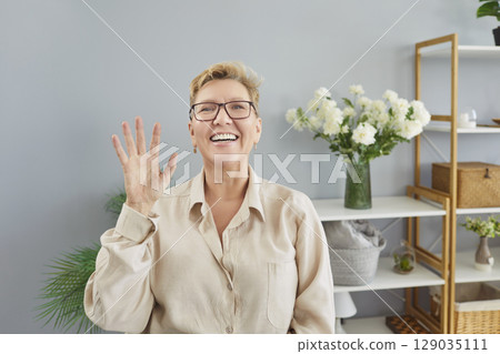 Happy Senior Woman Waving During Video Call At Home 129035111