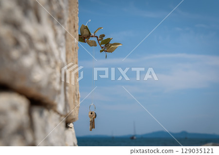 Symbolic keys to a wiindmill in the harbor at Garitsa Bay near Kerkyra on the island of Corfu, Ionian Sea, Greece 129035121