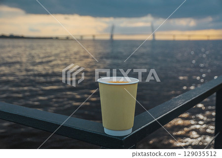 cup of drink coffee of trendy cream color against on shore of bay with Vantiv bridges in blur 129035512