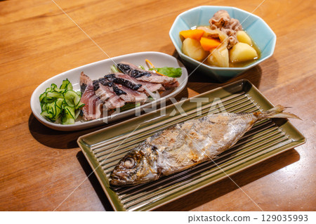 A dinner table with grilled fish, meat and potato stew, and seared bonito A dinner table with grilled fish, meat and potato stew, and seared bonito 129035993