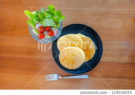 A refreshing breakfast table with pancakes and salad A refreshing breakfast table with pancakes and salad 129036054