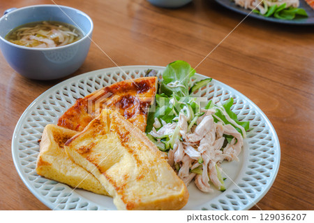 A breakfast plate featuring French toast, salad chicken, and pizza A breakfast plate featuring French toast, salad chicken, and pizza 129036207