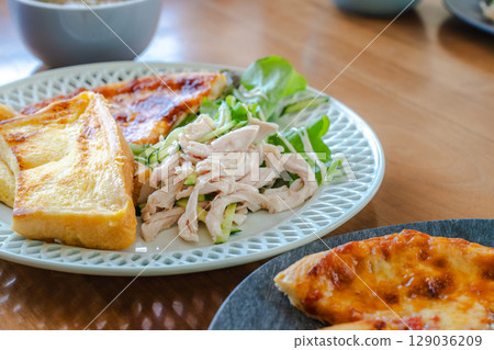 A breakfast plate featuring French toast, salad chicken, and pizza A breakfast plate featuring French toast, salad chicken, and pizza 129036209
