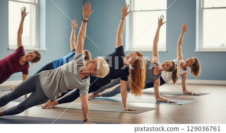 Women Practicing Yoga in a Studio 129036761