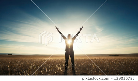 Silhouette of a Person Celebrating at Sunset in a Field - AI generated image 129036785