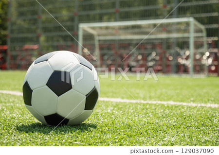 Soccer Ball on Field in Front of Goal Post 129037090