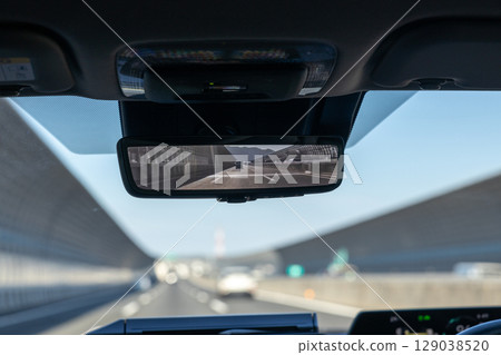 A car with a digital rearview mirror driving on a highway A car with a digital rearview mirror driving on a highway 129038520