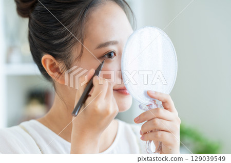 使用眼線筆的年輕女子 使用眼線筆的年輕女子 129039549