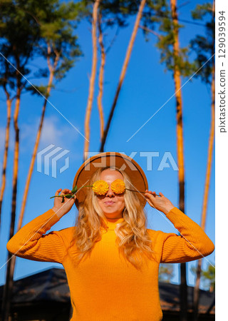 Woman close her eyes with yellow dahlia Autumn garden colorful flowers. Beautiful autumnal bouquet dahlia chrysanthemum. Red pink orange fall color fall floral background. Flower shop and florist 129039594