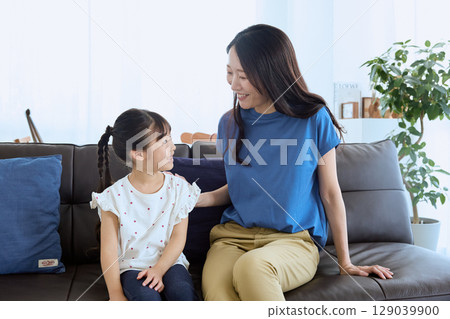 Mother and daughter having a fun conversation in the living room – Homely 129039900
