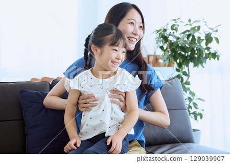 母親和女兒在客廳裡愉快地交談——Homely 母親和女兒在客廳裡愉快地交談——Homely 129039907