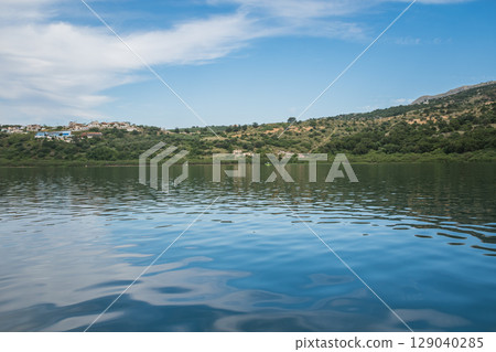 Lake Kournas in Crete, view of surrounding mountains and houses from a pedal boat from the lake 129040285