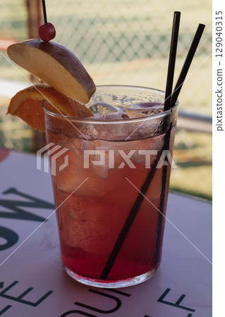Strawberry mojito in a glass on the table with a slice of orange and apple 129040315