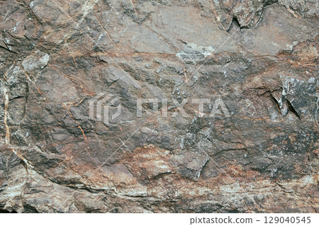 Texture of a massive stone with patterns and growths, natural background with shades and designs 129040545