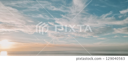 Natural sky background with torn clouds and sunset light 129040563