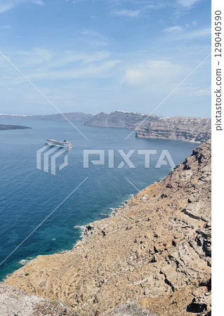 Cruise ship departing from the volcanic island of Santorini toward other islands and destinations 129040590