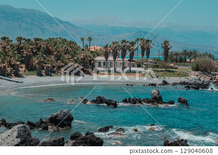 Paradise landscape on Greek island. Summer vibes on the seashore. Cozy house surrounded many palms 129040608