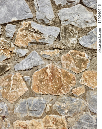 Stone wall texture background with natural masonry and cement joints 129040646