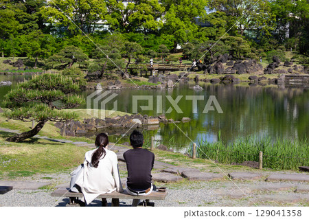 A cup of tea sitting on a bench looking out at the pond at the Kyu-Shiba Rikyu Gardens A cup of tea sitting on a bench looking out at the pond at the Kyu-Shiba Rikyu Gardens 129041358
