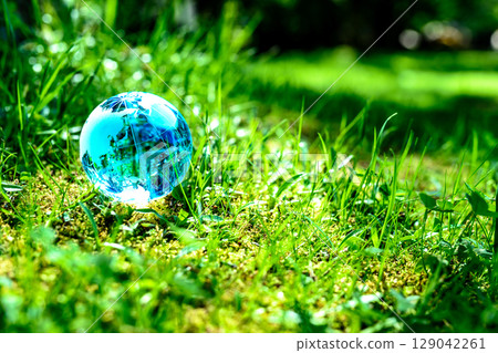 A crystal globe in a field of grass. Ecological image. Light blue. 129042261