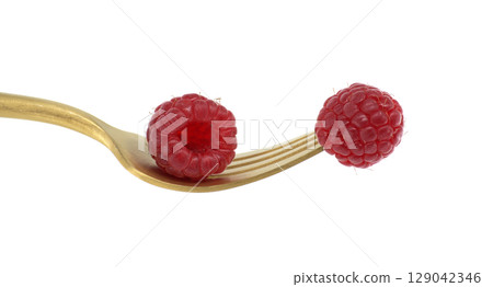 Ripe raspberries on a golden fork isolated on white background 129042346