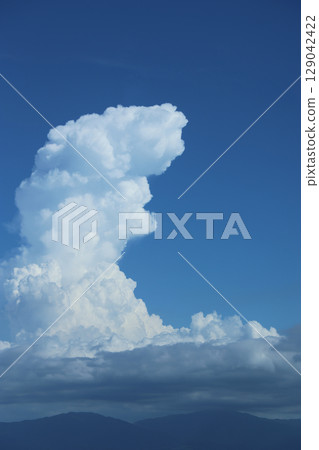 Picturesque cumulonimbus clouds with height, vertical, and mountains Picturesque cumulonimbus clouds with height, vertical, and mountains 129042422