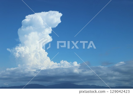 Picturesque cumulonimbus clouds with height, horizontal, and mountains Picturesque cumulonimbus clouds with height, horizontal, and mountains 129042423