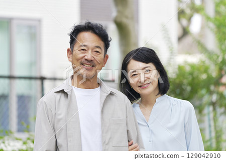 Middle-aged couple with arms folded, portrait, outdoors Middle-aged couple with arms folded, portrait, outdoors 129042910