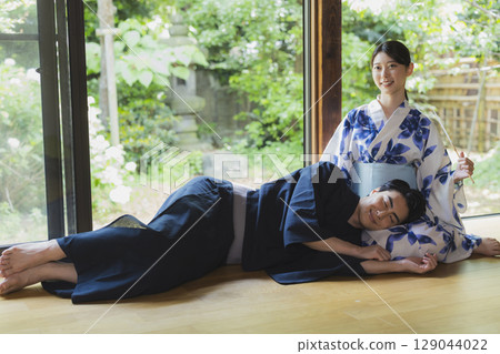 Couple in yukata resting on each other's laps 129044022