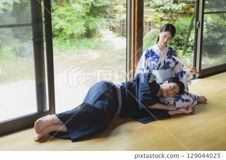 穿著浴衣的情侶互相依偎在對方的腿上 穿著浴衣的情侶互相依偎在對方的腿上 129044025