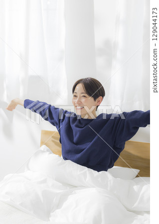 一個女人在床上伸展 129044173