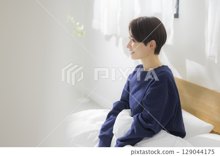 A woman stretching in bed A woman stretching in bed 129044175