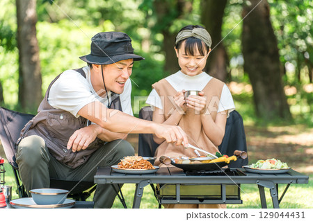 Camping, day camp, parent and child having a barbecue (father, daughter, girl, family camp) 129044431