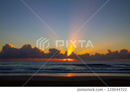 從澳洲昆士蘭州黃金海岸的海灘欣賞地平線上冉冉升起的太陽和陽光 129044722
