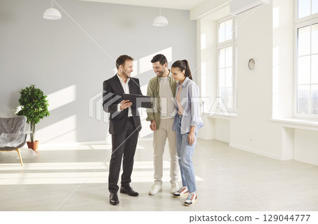 Realtor man meets couple, male licensed real estate agent, salesperson advertising property, helping 129044777