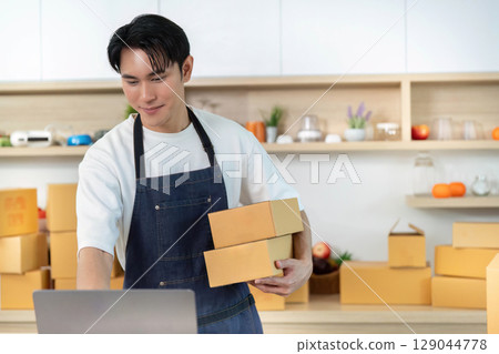 E-commerce. Employee carrying packages in shipping department. E-commerce. Employee carrying packages in shipping department. 129044778