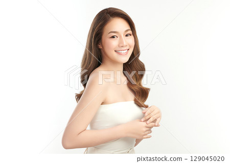A beautiful young Asian woman with clean, fresh skin against a white background. Skincare, facial treatment, cosmetology, beauty, and spa. An elegant portrait of an Asian woman. A beautiful young Asian woman with clean, fresh skin against a white background. Skincare, facial treatment, cosmetology, beauty, and spa. An elegant portrait of an Asian woman. 129045020