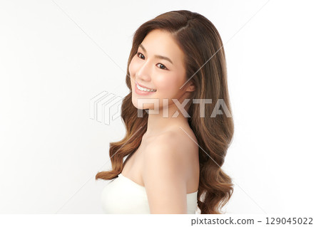 A beautiful young Asian woman with clean, fresh skin against a white background. Skincare, facial treatment, cosmetology, beauty, and spa. An elegant portrait of an Asian woman. 129045022