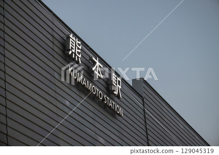 March 25 2025 Illuminated Kumamoto Station Sign Against a Clear Evening Sky, Japan 129045319