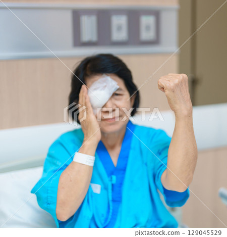 Elderly Woman with eye protective shield after eye surgery. Eye disease, Cataract, Glaucoma, Age Related Macular Degeneration, Diabetic Retinopathy, Vitreous, Lasik, World Glaucoma day and health Elderly Woman with eye protective shield after eye surgery. Eye disease, Cataract, Glaucoma, Age Related Macular Degeneration, Diabetic Retinopathy, Vitreous, Lasik, World Glaucoma day and health 129045529