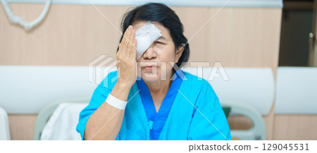 Elderly Woman with eye protective shield after eye surgery. Eye disease, Cataract, Glaucoma, Age Related Macular Degeneration, Diabetic Retinopathy, Vitreous, Lasik, World Glaucoma day and health Elderly Woman with eye protective shield after eye surgery. Eye disease, Cataract, Glaucoma, Age Related Macular Degeneration, Diabetic Retinopathy, Vitreous, Lasik, World Glaucoma day and health 129045531