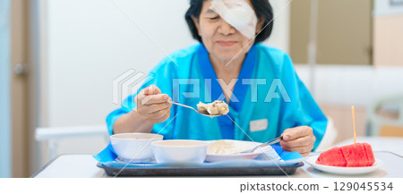 Senior Woman eating food after eye surgery in hospital . Eye disease, Cataract,  Glaucoma, Age Related Macular Degeneration, Diabetic Retinopathy, Lasik, World Glaucoma day and health treatment 129045534